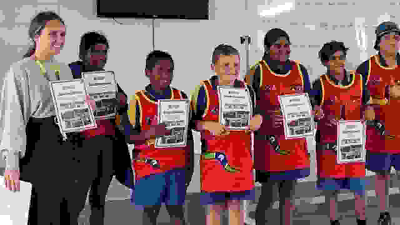 a group of kids and teachers posing with their awards